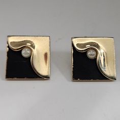 Swank Gold Tone Black Enamel Faux Pearl Cufflinks Add a touch of sophistication to your formal attire with these Swank cufflinks. The gold tone metal and black enamel finish complement each other beautifully, giving a sleek and stylish appearance. The faux pearls add a touch of elegance to the design, making these cufflinks a great addition to any jewelry collection. Perfect for weddings, graduations, or any formal event, these cufflinks are a must-have for any fashion-conscious man. Very Nice P Elegant Rectangular Clip-on Earrings For Formal Events, Formal Enamel Clip-on Earrings, Modern Enamel Earrings For Formal Occasions, Modern Formal Enamel Earrings, Classic Enamel Earrings For Formal Occasions, Gold Clip-on Cufflinks For Business, Classic Formal Enamel Earrings, Gold Clip-on Jewelry For Business, Formal Enamel Jewelry