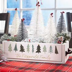 a wooden box filled with christmas trees sitting on top of a table