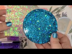 someone is holding a blue and green glitter ball