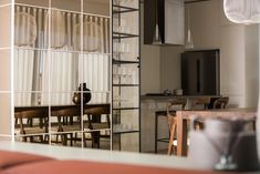 the reflection of a dining room table and chairs in a glass doored wall mirror