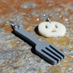 a pair of hair clips sitting on top of a stone surface next to a button