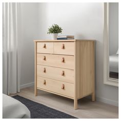 a wooden dresser sitting next to a window with a plant on it's top