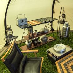 the inside of a tent with chairs, tables and cooking utensils in it