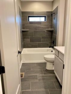 a white toilet sitting next to a bath tub in a bathroom under a skylight