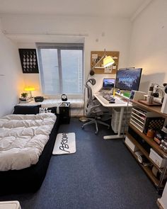 a bed room with a neatly made bed and a computer on top of the desk