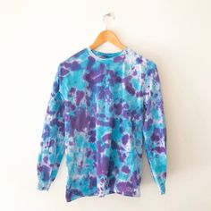 One of a kind, hand-dyed blue and purple tie dye long sleeve top 100% cotton Unisex size S Care instructions: Wash separately in cold water. Colors may change over time. Please note that this is a hand-dyed garment and there may be small imperfections. Purple Hand Dyed Tops For Spring, Pre-washed Blue Tops For Fall, Blue Fall Tops, Blue Long Sleeve Bleached Top, Hand-dyed Blue Tops For Spring, Hand Dyed Purple Cotton Tops, Cap Sleeves Blouse, Black Graphic Tees, Purple Tie Dye