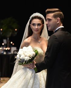 a bride and groom are standing together at their wedding ceremony in front of an audience