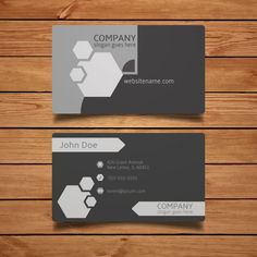 two gray business cards with white and black designs on wood planks, one is for webtemme com