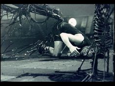 a man laying on the ground in front of a tree branch with his head down