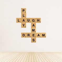 scrabble tiles spelling the word dream on a white wall in an empty room