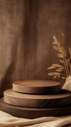 three wooden plates stacked on top of each other next to a vase with flowers in it