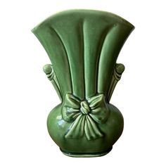 a green vase with a bow on the top is shown in front of a white background