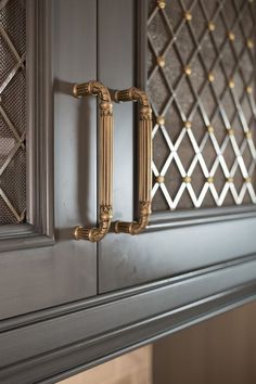 a close up of a door handle on a cabinet with gold trim and diamond design