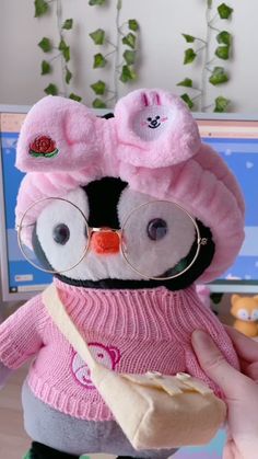 a stuffed animal wearing glasses and a pink sweater