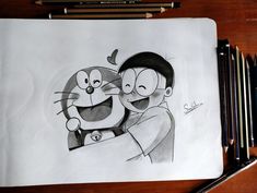 a drawing of two people hugging each other on a piece of paper with pencils next to it