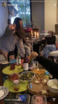 two women sitting at a table with food on it