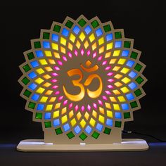 an illuminated lamp depicting the symbol of omsagram in multicolored glass on a white stand