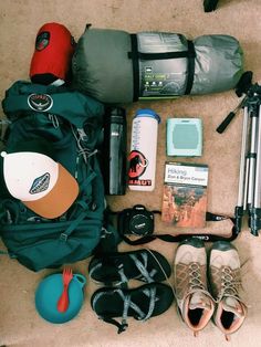 the contents of a backpack laid out on the floor next to shoes and other items