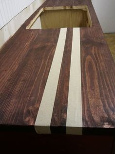 a wooden counter top with white stripes on the edge and wood in the bottom half