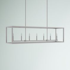 a long rectangular light fixture with candles hanging from it's sides and four lights on each end