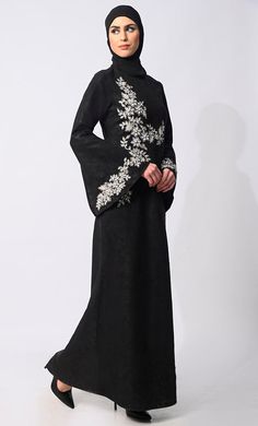 Step into the grace and charm of Eid celebrations with our exclusive Abaya Collection, featuring the epitome of elegance and sophistication. Our machine embroidered Abaya, meticulously adorned with pearl and stone handwork, is a testament to timeless beauty and exquisite craftsmanship. Crafted with meticulous attention to detail, this Abaya boasts delicate machine and Hand embroidery with stones and Pearls that adorns every inch, creating a mesmerizing tapestry of intricate patterns. Each stitch reflects a dedication to perfection, enhancing the allure of this traditional garment. The Abaya also features Round neck, flared sleeves , back zip closure and a loose belt for a cinched waist silhouette effect. Size & FitModel height is 5’9’ and is wearing a Small sizeMaterial & CareMaterial: Kor Embroidery With Stones, Abaya With Belt, Embroidered Abaya, Eid Celebrations, Blue Abaya, Abaya Collection, Black Abaya, The Grace, Intricate Patterns