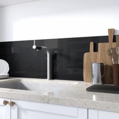 a white kitchen sink sitting under a faucet next to a wooden cutting board