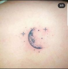 a small crescent tattoo on the back of a woman's shoulder