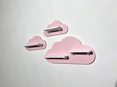 there are three pink clouds on the wall with shelfs above them and one has a laptop in it