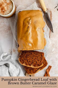 a loaf of bread sitting on top of wax paper next to cinnamon sticks and two mugs