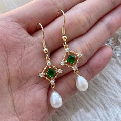 Handmade 14K REAL gold-filled green emerald/crystal lace dangle earrings, with genuine natural ivory pearls. Stunning emerald gemstone gives elegant, classy and dainty sparkles. Absolutely modern elegant minimalism. Each earring is crafted with care using high-quality materials, including genuine emeralds, natural pearls, and 14K gold-filled lace. The intricate lace design adds a touch of old-world glamour to these earrings, making them perfect for any special occasion. Whether you're looking to Green And Gold Wedding Jewelry, Gold Jewelry With Green Dress, Wedding Earrings Emerald, Green And Gold Outfit Classy, Emerald Dangle Earrings, Emerald Wedding Earrings, Emerald And Gold Earrings, Pearl And Emerald Earrings, Green Wedding Earrings