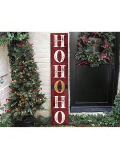 a wooden sign that says hohoo on the side of a building next to christmas trees