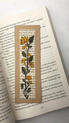 an open book with yellow flowers on it