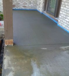 an empty patio in front of a brick building with blue tape on the floor and windows