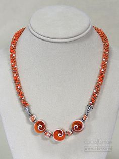 Creamsicle Necklace #3. Happy colors! These exceptional lollypop beads of orange resin and operculum shell, add a fun vibe to your jewelry collection. Wear this necklace to brighten up your day in either Summer or Autumn! The focal beads are amazing natural operculum shells that have had their hollow area filled with orange resin.You can see the spiraling formation and the orange resin brings out the natural orange/peach/cream colors of the shells. Subtle gradations of orange, giving way to crea Orange Round Beaded Necklace With Lobster Clasp, Orange Necklaces With Round Beads And Lobster Clasp, Orange Necklace With Round Beads And Lobster Clasp, Orange Beaded Necklaces With Lobster Clasp, Adjustable Orange Czech Glass Necklace, Orange Czech Glass Beaded Necklaces, Orange Beaded Necklaces With Czech Glass, Handmade Orange Beaded Necklaces With Czech Glass, Handmade Orange Czech Glass Beaded Necklaces