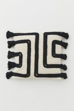 two black and white pieces of cloth with tassels on the ends, one in the shape of an e