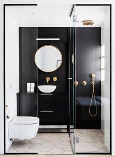 a black and white bathroom with gold accents