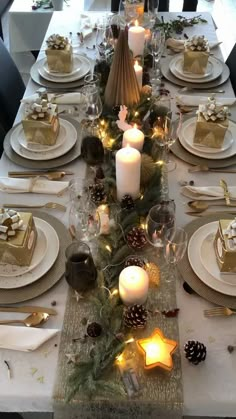 the table is set with candles, plates and napkins for christmas dinner guests to enjoy