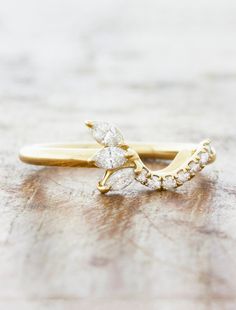 a yellow gold ring with two diamonds on it