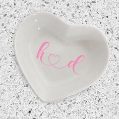 a heart shaped dish with the word k o d painted on it's side