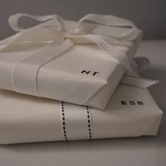 two folded white sheets with ribbons tied around them