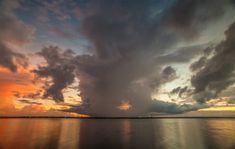 the sky is reflected in the water as it looks like clouds are coming up from the ocean