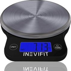 a digital clock sitting on top of a black table next to a silver plate with the word inewfit written below it