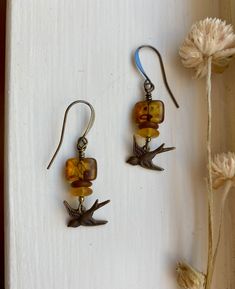 "murmuration ~ vintage-style antique brass bird earrings with earthy tortoiseshell amber, terracotta, wildflower yellow, and gleaming accents Details & measurements: ~ Sweet little antique brass, vintage style bird charms (17 x 7mm) are hanging from  gorgeous small rectangle amber Czech glass beads with an earthy Picasso finish, giving them a tortoiseshell look (12 x 8mm) ~ Accented by Czech glass rondelle spacer beads in matte terracotta (7mm), frosted wildflower yellow colored saucer beads (6mm), and tiny sparkling metallic Czech glass spacer beads ~ They hang from antique brass ear wires ~ Earrings hang approx. 1 3/4\" long ♡ Packaged safely & sustainably in a kraft box with cotton ribbon & dried organic florals. This makes for a beautiful gift, or something pretty for yourself! All pac Earth Tone Jewelry, Earthy Earrings, Cottagecore Jewelry, Boho Birds, Brass Bird, Cotton Ribbon, Store Jewelry, Earrings Antique, Bird Charm