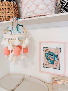 a white sink sitting under a mirror next to a shelf filled with pictures and other items