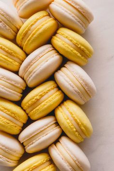 a pile of yellow and white macaroons sitting on top of each other