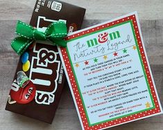 a candy bar with a green bow on top of it next to a card that says the m & m nature's girl