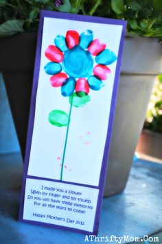 a card with a flower on it sitting next to a potted plant