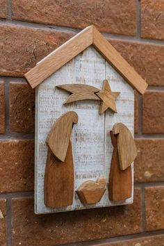 a wooden nativity scene on a brick wall