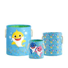 three children's storage bins with shark and fish designs on them, one is blue