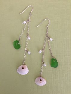 "*E110  * These adorable beachy earrings are sure to catch your eye.  The sterling silver ear wire has two sterling silver chains dangling from it.  The shorter chain has one 4mm white seed pearl and one approximately 1/2\" piece of real green beach glass dangling from it.  The longer chain has two 4mm white seed pearls with one approximately 3/4\" white bivalve cup shell at the end.  * These earrings will dangle approximately 4\" from the top of the earwire.  *All of my jewelry is one of a kind Beach Dangle Earrings Wire Wrapped, Nickel Free Sterling Silver Jewelry For Beach, Green Dangle Jewelry For The Beach, Beach Dangle Jewelry, Silver Dangle Earrings For The Beach, Nickel-free Sterling Silver Jewelry For The Beach, Sterling Silver Beach Earrings, Silver Dangle Earrings For Vacation, Sterling Silver Earrings For Summer Beach